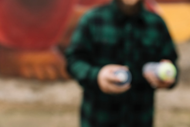 Free photo blurred man holding aerosol spray can in hand