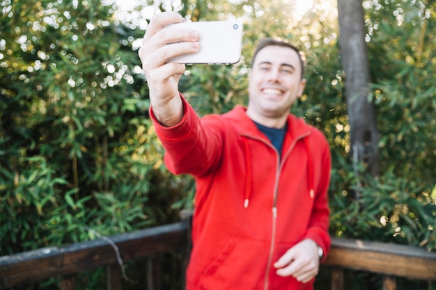 Free Photo blurred man taking selfie in park