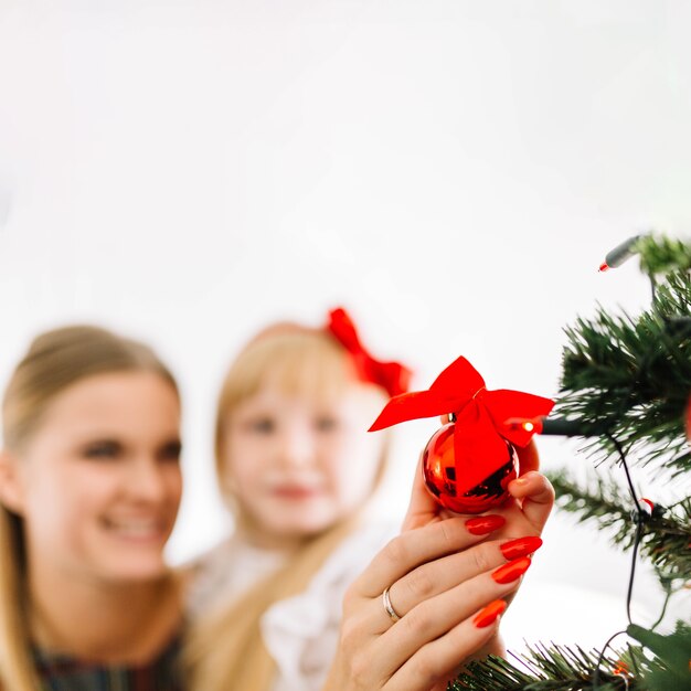 Blurred mother and daughter decorating christmas tree