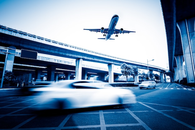 Free photo blurred street scene in city with a plane flying over