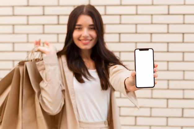 Free Photo blurred woman showing copy space mobile phone