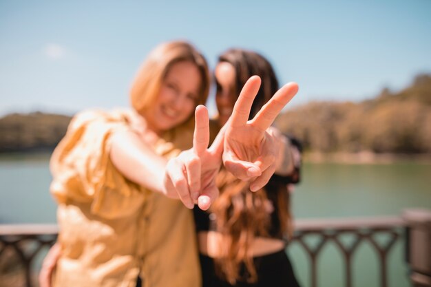 Blurred women gesturing peace