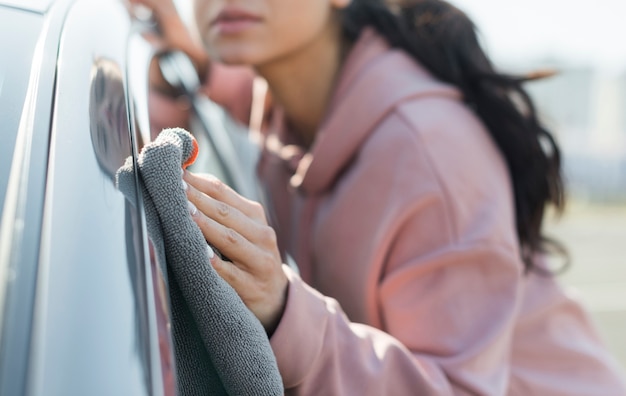 Free Photo blurred young woman cleaning the car