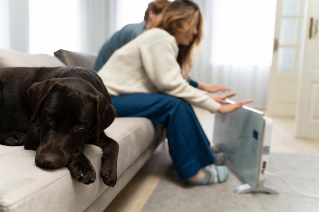 Blurry couple warming up with heater at home