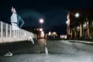 Free photo blurry man in twilight running on road