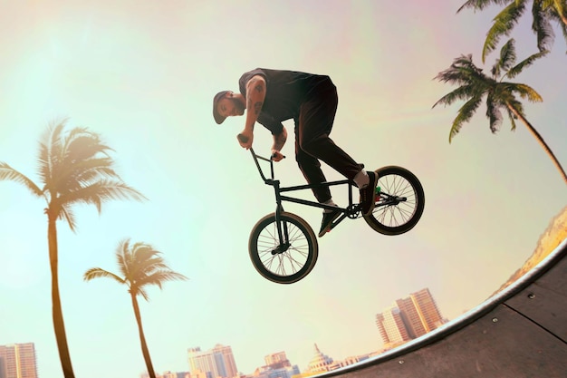 Free Photo bmx rider is performing tricks in skatepark on sunset