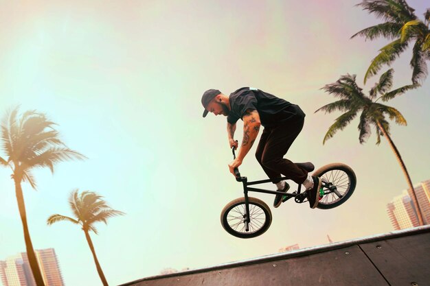 Free Photo bmx rider is performing tricks in skatepark on sunset