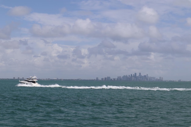 Boat in the blue sea with city buildings on the surface