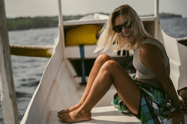 Free Photo boat trip in bali. a young woman in sunglasses is sailing on a boat to a nearby island.