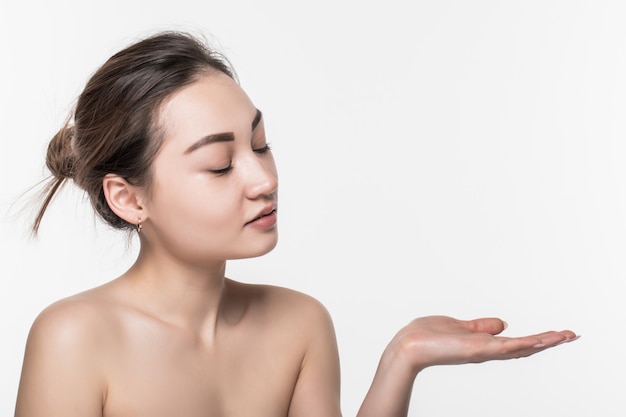 Free photo body skincare care beauty asian woman showing product on side with open hand presenting and displaying isolated on white wall.