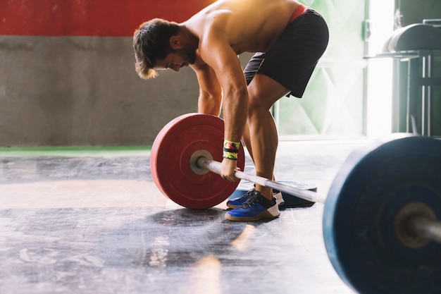 Bodybuilding concept with man mounting barbell