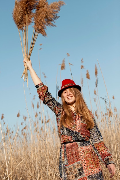 Free photo bohemian woman posing with dead grass