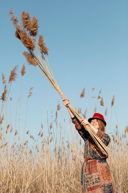 Free Photo bohemian woman posing with tall dead grass