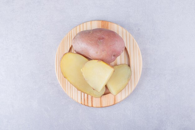 Boiled delicious potatoes on wooden plate. 