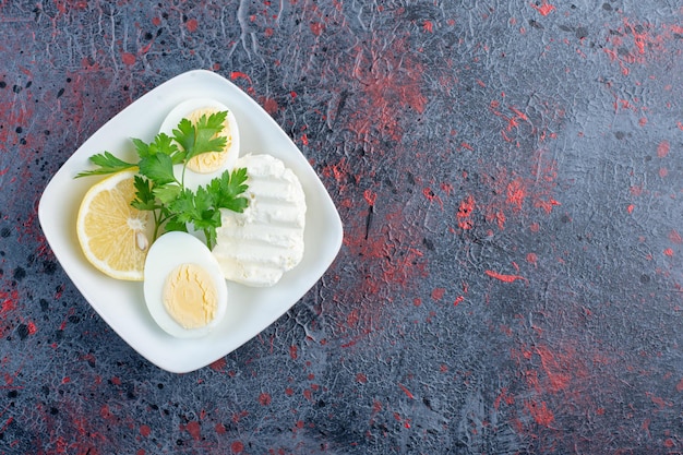 Free photo boiled egg with white cheese and herbs.