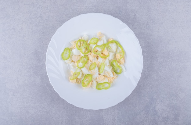 Boiled eggs and pepper slices in white plate. 