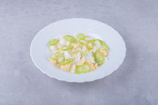 Boiled eggs and pepper slices in white plate. 