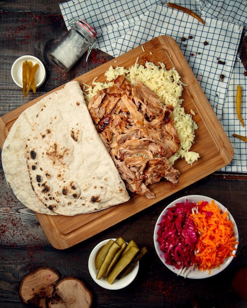 Free photo boiled rice with pieces of chicken on a wooden board