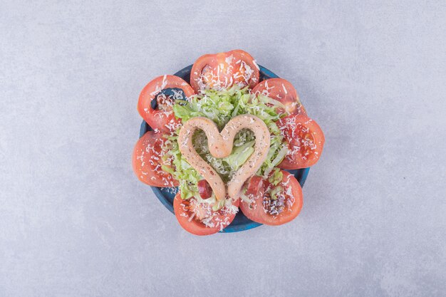 Free Photo boiled sausages shaped like heart and tomato slices. 