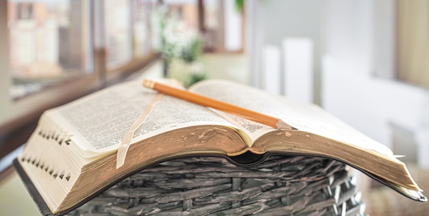 Book Bible with pencil close-up, on the background of a beautiful terrace. Morning time.