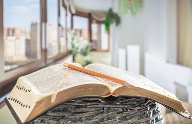 Book Bible with pencil close-up, on the of a beautiful terrace.