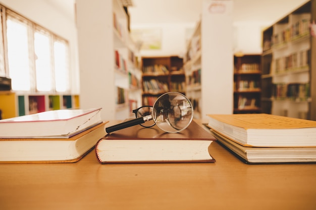 Free photo book in library with old open textbook, stack piles of literature text archive on reading desk