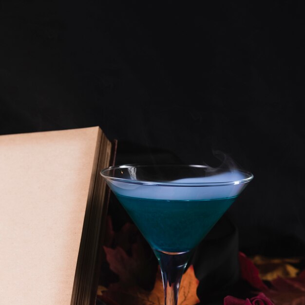 Free Photo book with drink on black background