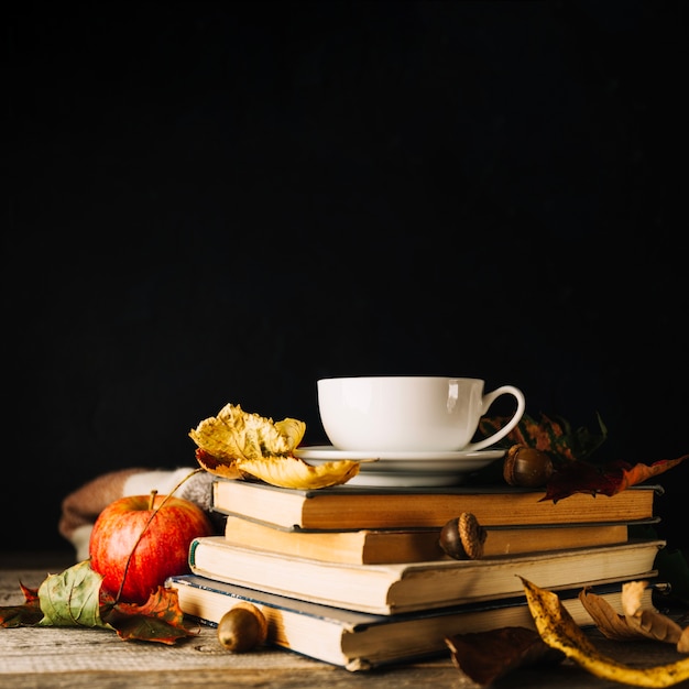 Books and leaves on black background