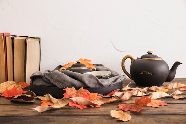 Free photo books and leaves near tea set