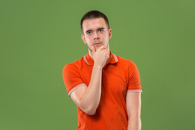 Bored man. Boring, dull, tedious concept. Young caucasian emotional man.  Studio Isolated on trendy green background