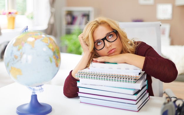 Boring young girl with stack of books