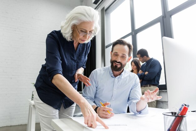 Boss assisting her employee with documents