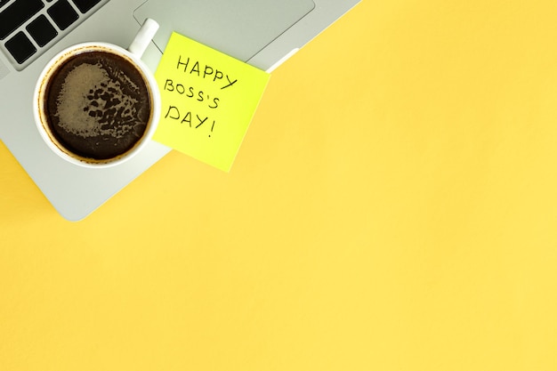 Free Photo boss day concept laptop and cup of coffee on a yellow background flat lay