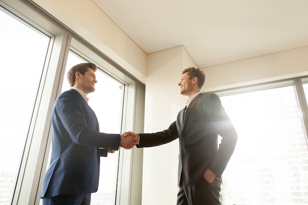 Free photo boss shaking hand and thanking worker for good job