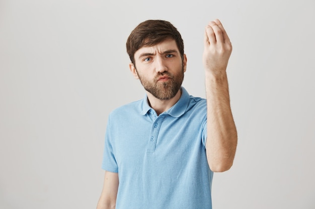 Bothered and annoyed young bearded man posing