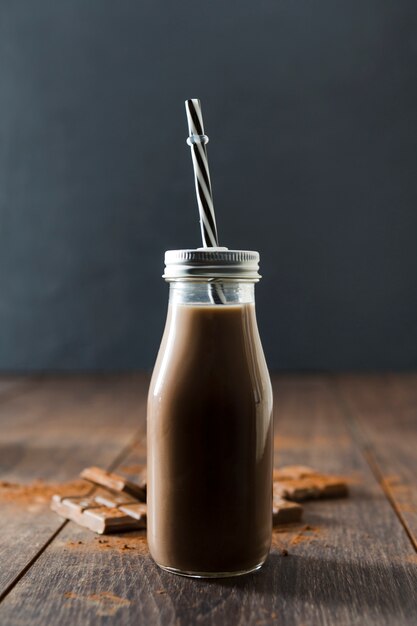 Bottle of chocolate milkshake with straw