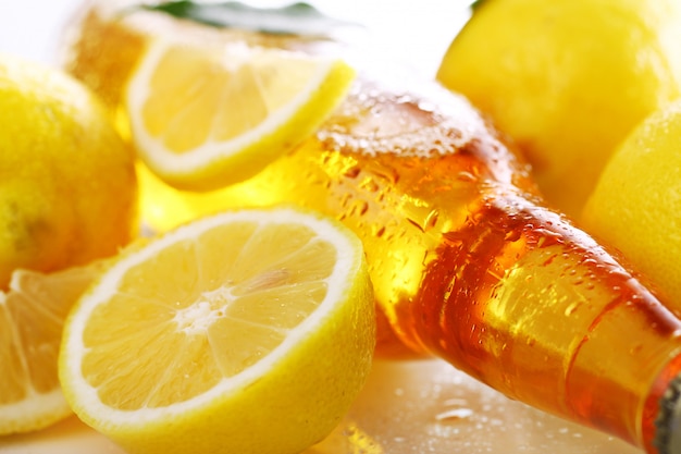 Free photo bottle of cold beer with fresh lemons