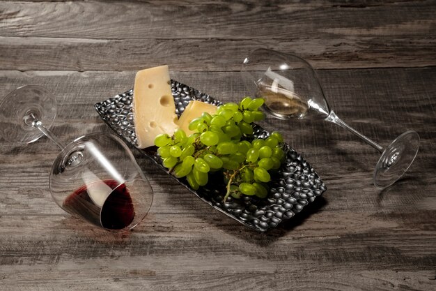 A bottle and glasses of red and white wine with fruits