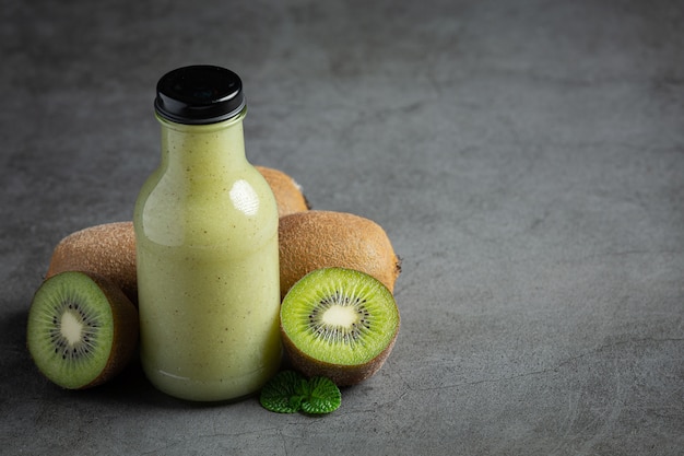 Free Photo bottle of kiwi juice put on dark floor