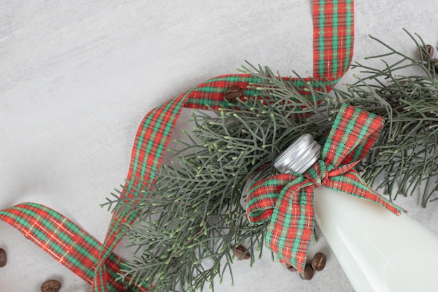 Free photo bottle of milk tied with ribbon and coffee beans