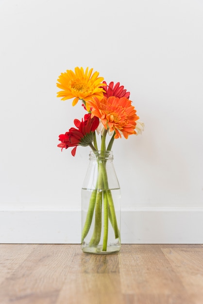 Free Photo bottle with flowers standing on floor