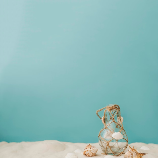 Free Photo bottle with rope and seashells on sand