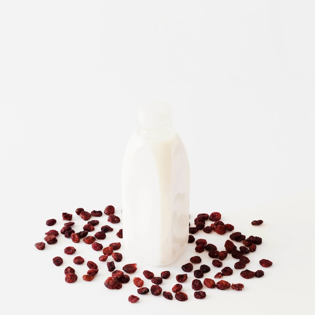 Free photo bottle with white liquid between dried fruits