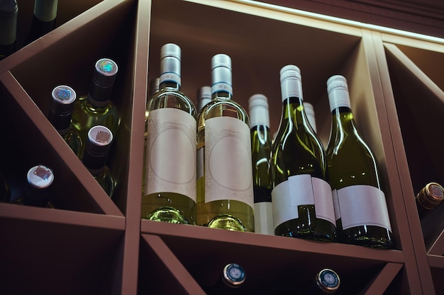 Free photo bottles of tasty wine in posh reastoraunt are stored on the shelf.