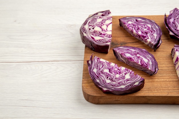 Bottom half view chopped red cabbages on wood board on white table free space