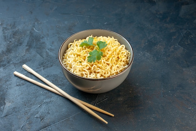 Free Photo bottom view asian ramen noodles with coriander in bowl chopsticks on dark table