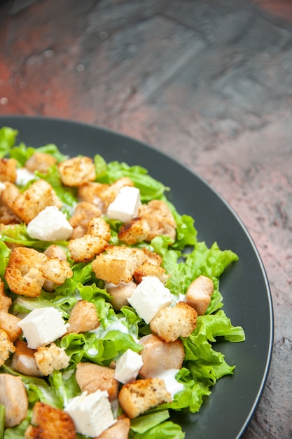 Free Photo bottom view caesar salad on oval plate on dark red table