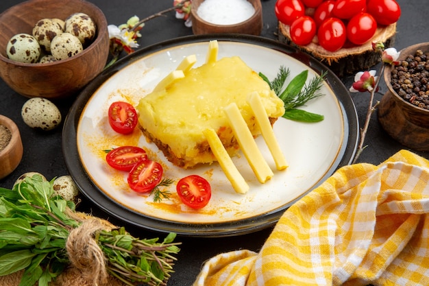 Bottom view cheesy bread cherry tomatoes and fries potatoes on plate spices and quail eggs in bowls