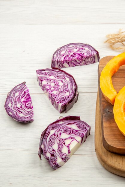 Bottom view chopped red cabbage squash on cutting boards on grey table