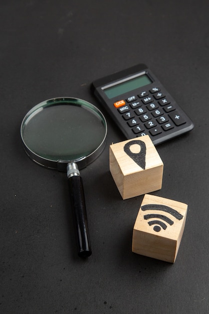 Free photo bottom view location and wifi icons on wood blocks on black background